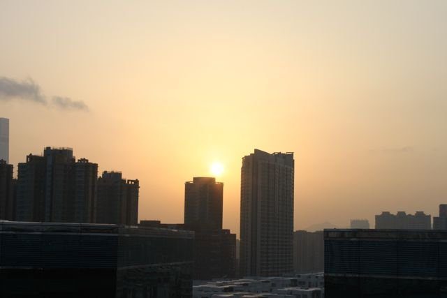 Sunset over Hong Kong skyline with buildings in silhouette