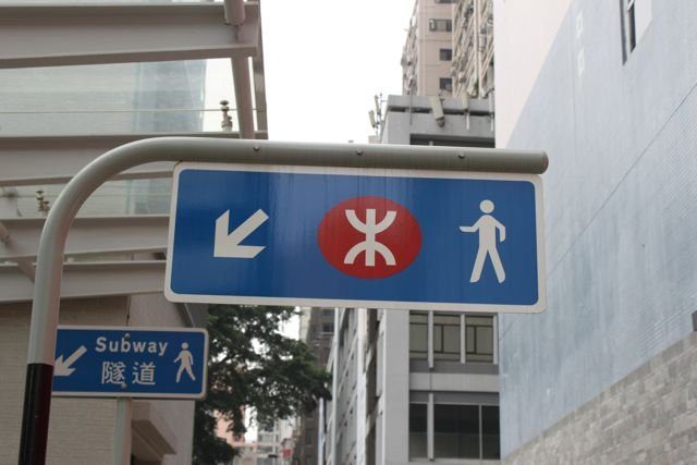 MTR street sign with the red logo between pedestrian arrows
