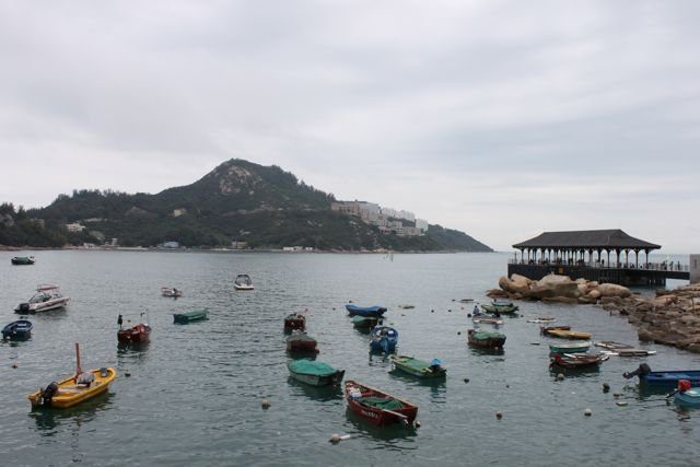 Fishing boats moored in Stanley Bay with hills and a pier behind