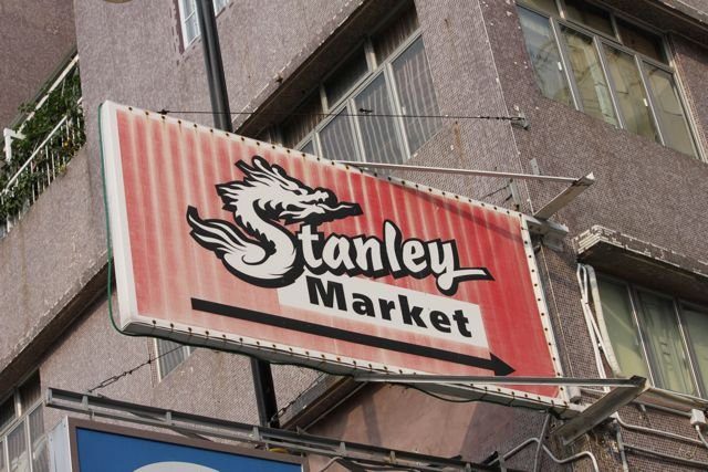 Stanley Market sign with dragon logo on the side of a building
