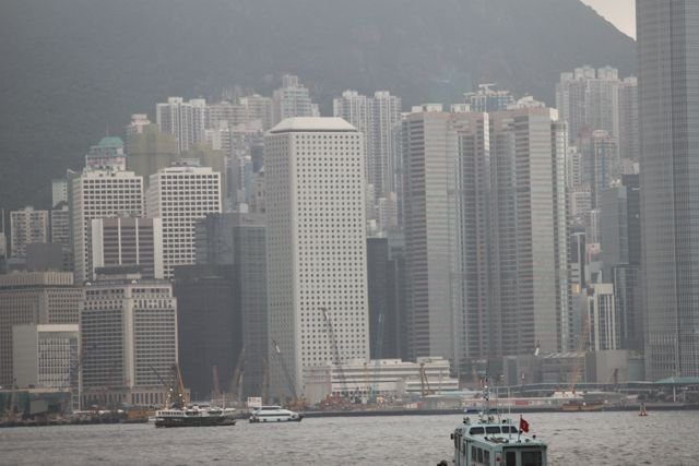 Dense Hong Kong Island skyline seen from the harbour on an overcast day