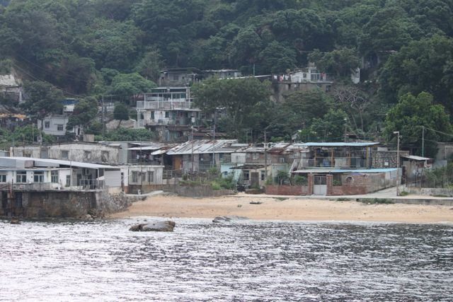 Ramshackle village houses on a hillside above a small beach