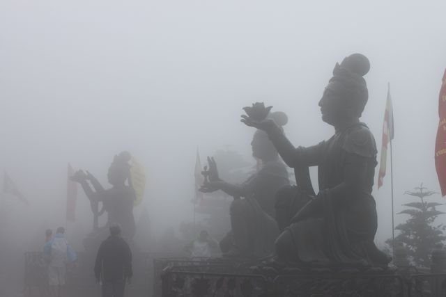 Buddhist offering statues at the Big Buddha in mist on Lantau Island