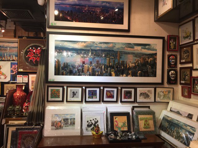 Gift shop wall crammed with framed Hong Kong skyline prints and souvenirs