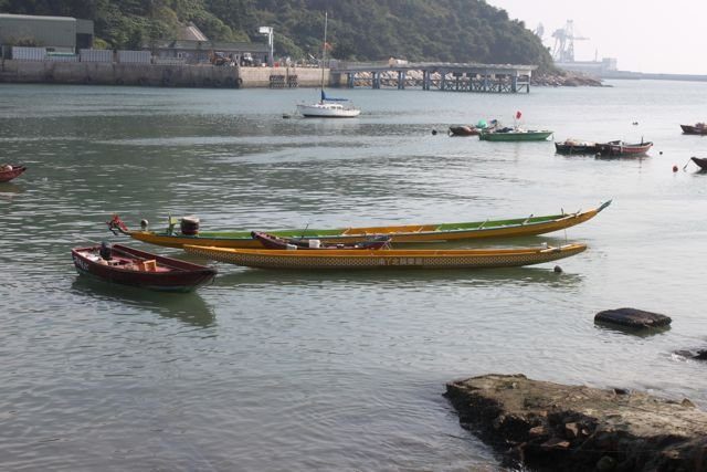 Dragon boats and small fishing boats moored in a calm island bay