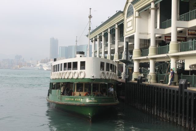Star Ferry docked at the Central pier with Kowloon skyline across the water
