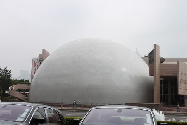 Hong Kong Space Museum dome with cars parked in front in Tsim Sha Tsui