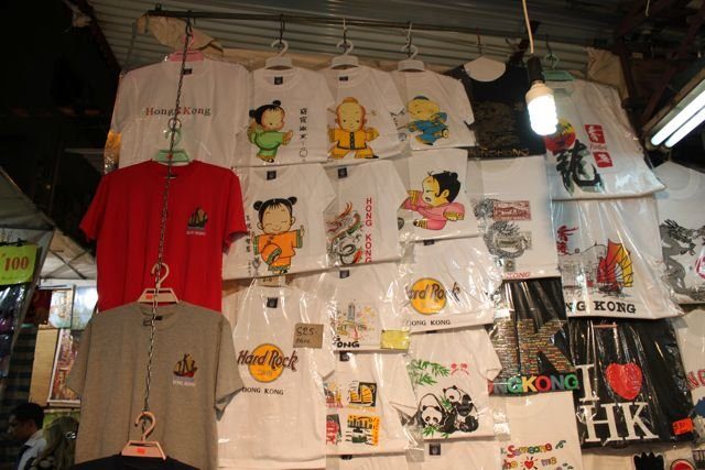 Tourist t-shirts and souvenirs displayed at a Hong Kong market stall