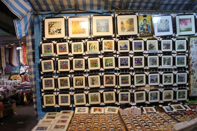 Framed paintings and artwork for sale at a night market stall