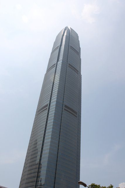 Two IFC tower rising to a point, glass facade disappearing into hazy sky