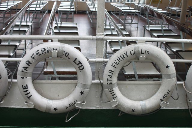 Two Star Ferry life rings mounted on the rail of an empty upper deck