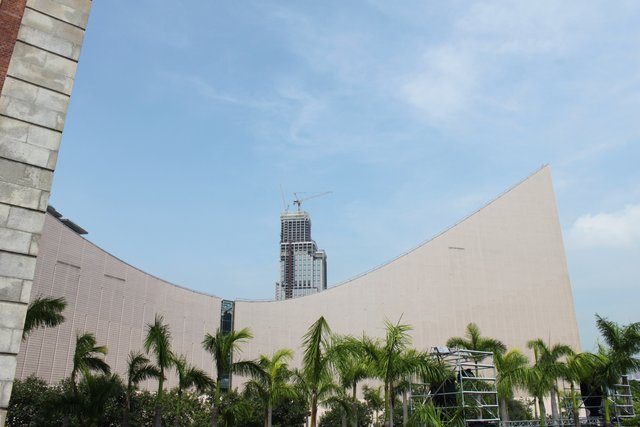 Curved roofline of the Hong Kong Cultural Centre with a tower crane behind